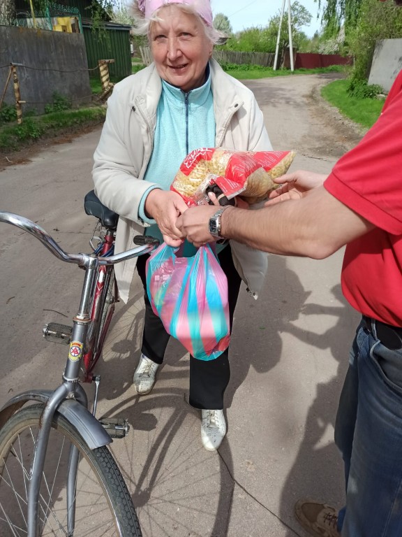 Kobieta trzymająca rower i odbierająca żywność